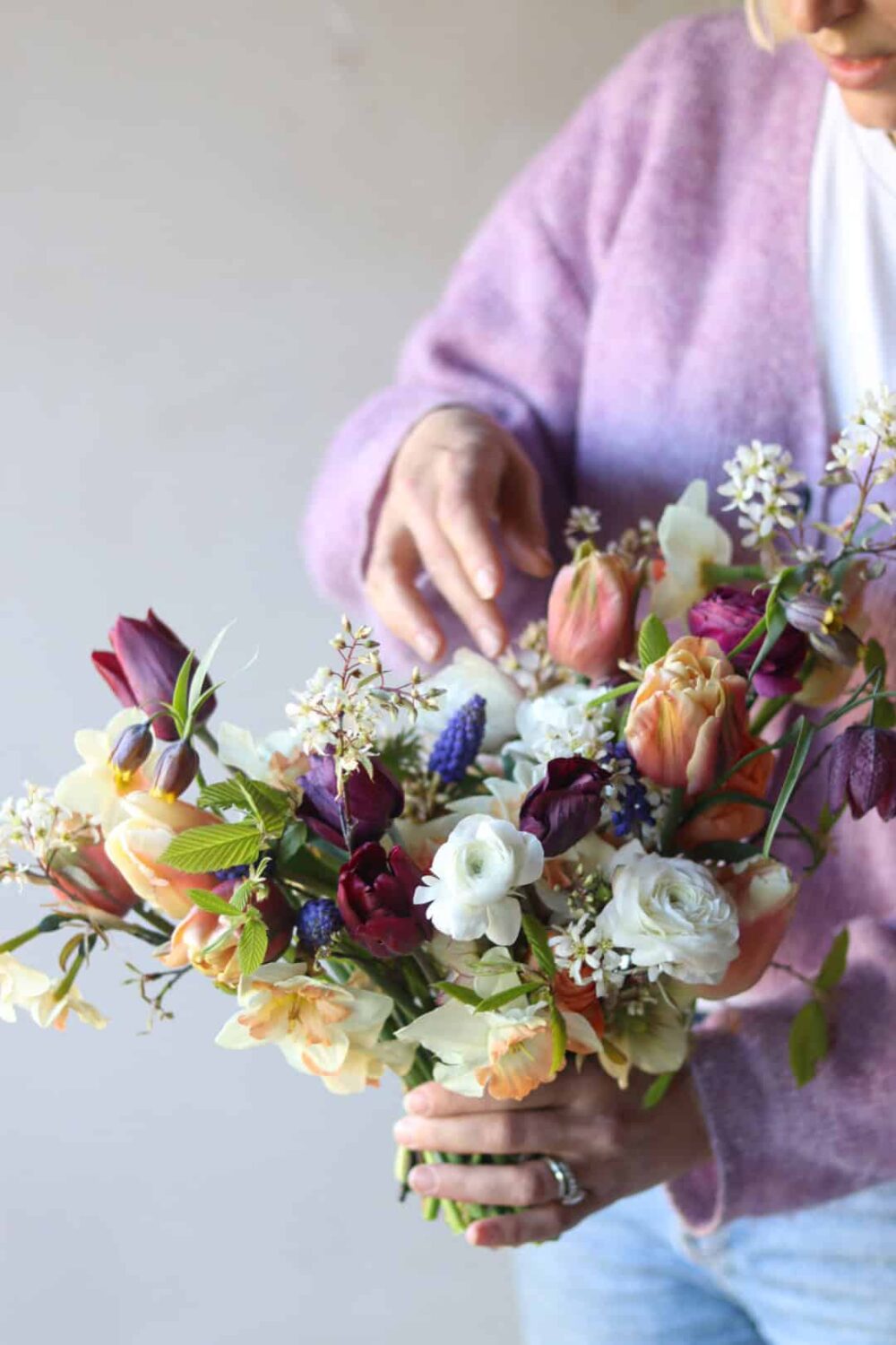 Florist Cissy Bullock is pictured holding a colourful bouquet of flowers.