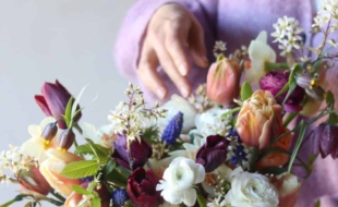 Florist Cissy Bullock is pictured holding a colourful bouquet of flowers.